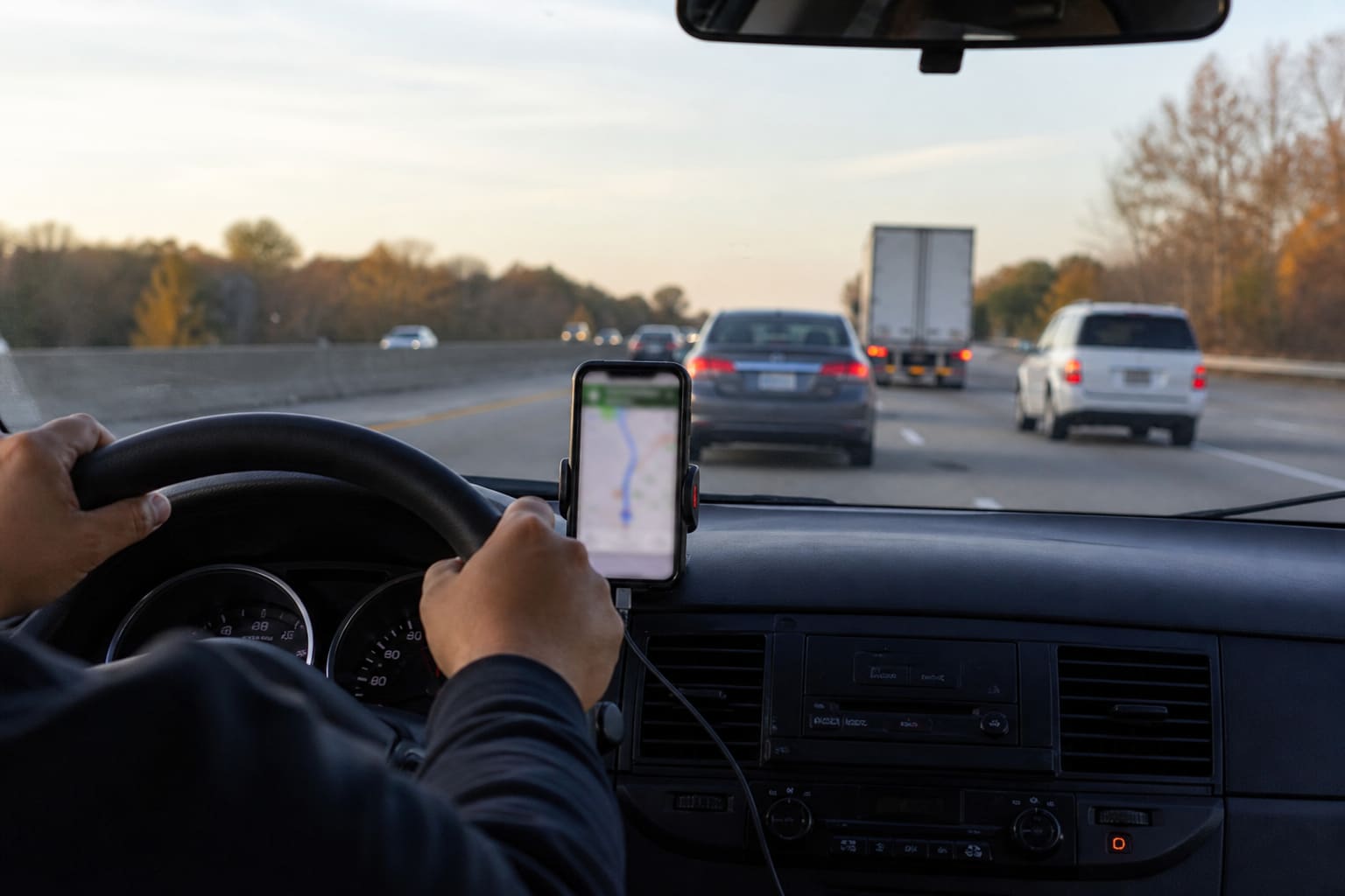 Driver checking navigation on a phone in traffic